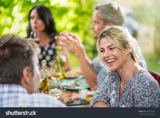 stock-photo-group-of-friends-gathered-around-a-table-on-a-terrace-in-the-summer-to-share-a-meal-focus-on-a-563314387
